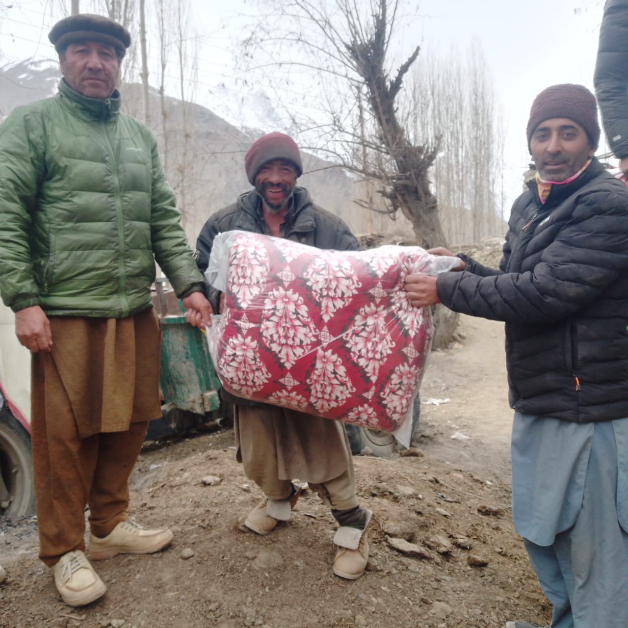 Giving warm clothes to people in Braldo Valley